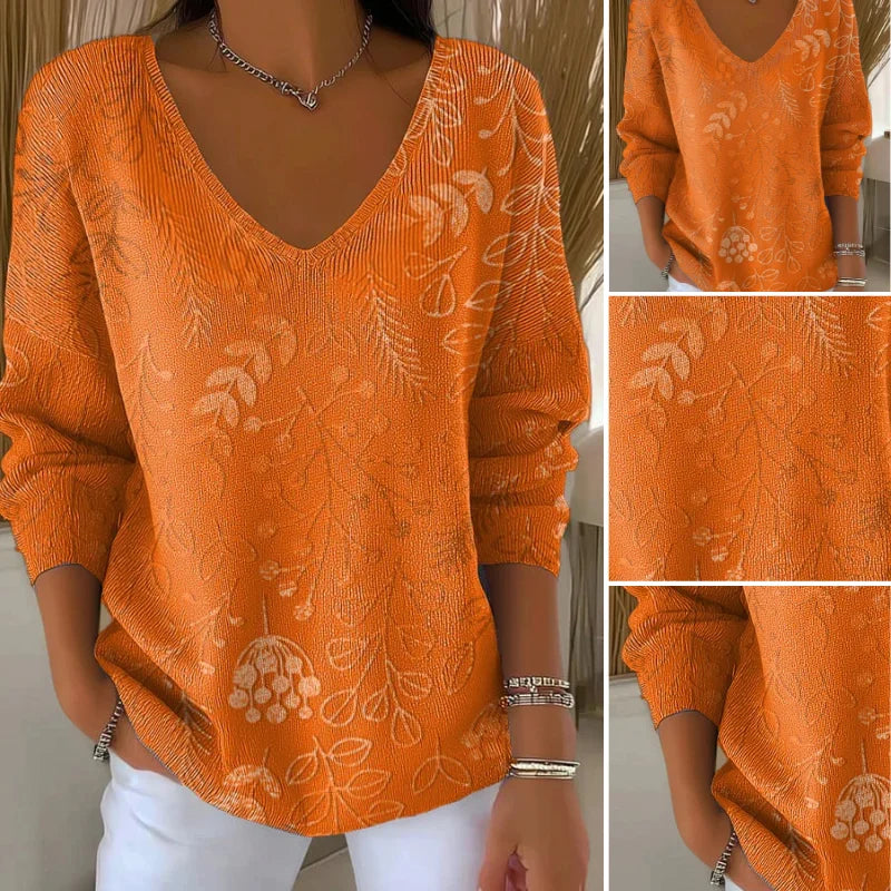 Damen Pullover mit V-Ausschnitt, gefertigt aus weichem Baumwollgemisch, mit floraler Musterung in sanften Farben.