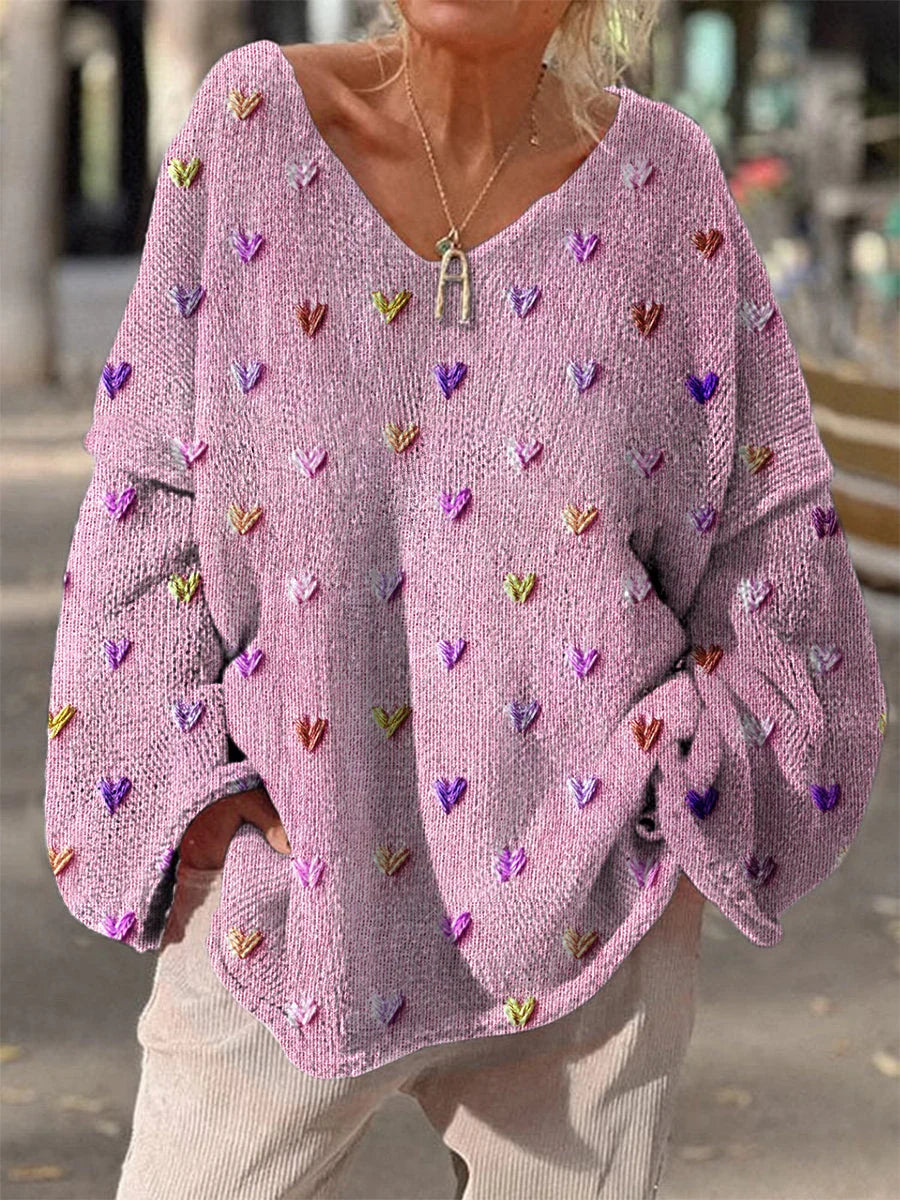 Rosa Damenpullover mit Herzdesign, weichem Material und lockerer Passform für einen lässigen Look.