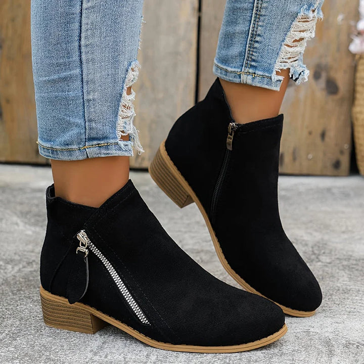 Damen Ankelstiefel aus weichem Leder mit seitlichem Reißverschluss und elegantem, minimalistischen Design in Schwarz.