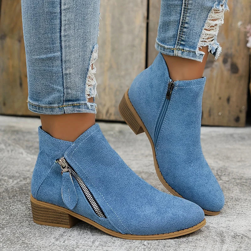 Damen Ankelstiefel aus schwarzem Leder mit seitlichem Reißverschluss und flachem Absatz für einen modernen Look.