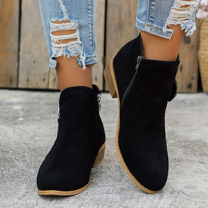 Damen Ankelstiefel aus robustem Leder mit seitlichem Reißverschluss und modischem, minimalistischen Design in Schwarz.