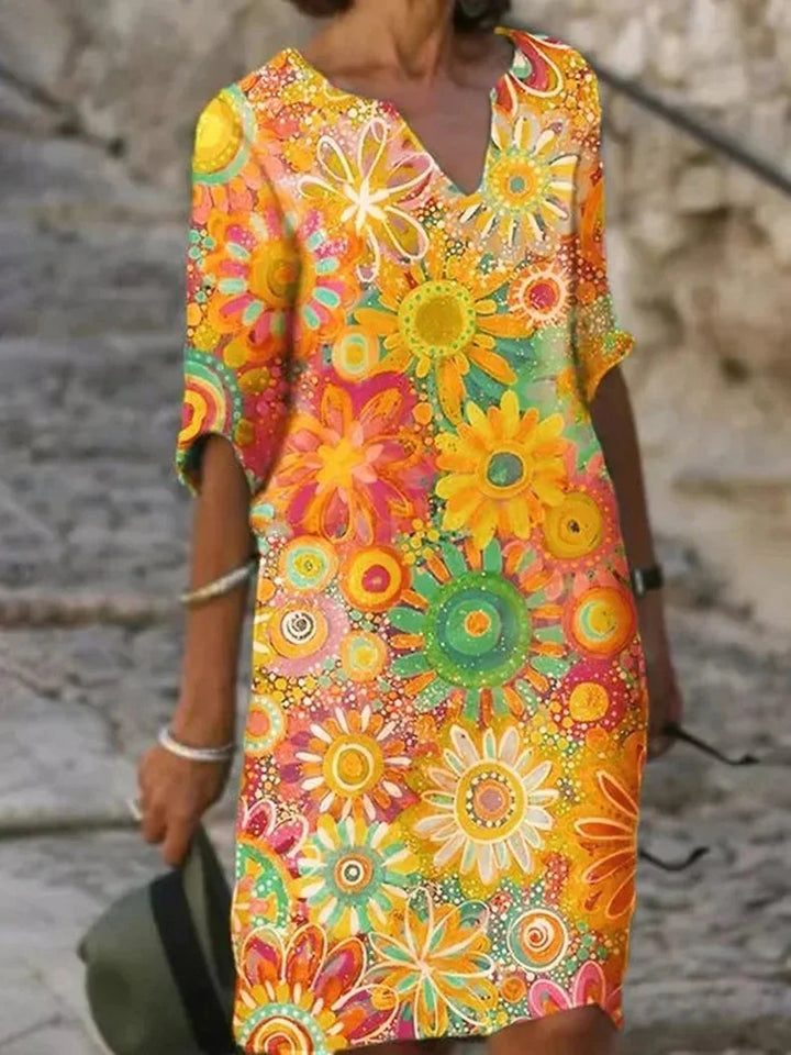 Gelbes Damen Blumenkleid mit V-Ausschnitt und Halbarm aus leichtem Stoff. Elegantes Design für sommerliche Anlässe.