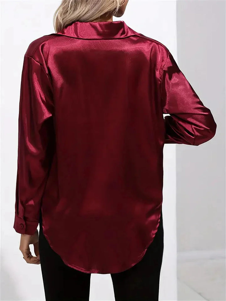 Damen Bluse aus Satin mit eleganten Knöpfen, weich glänzendes Material, figurbetontes Design und modische Details.