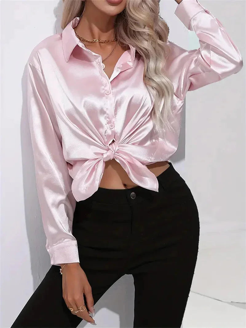 Rosa Satin Damenbluse mit eleganten Knöpfen, leicht glänzend und modern geschnitten, ideal für festliche Anlässe.