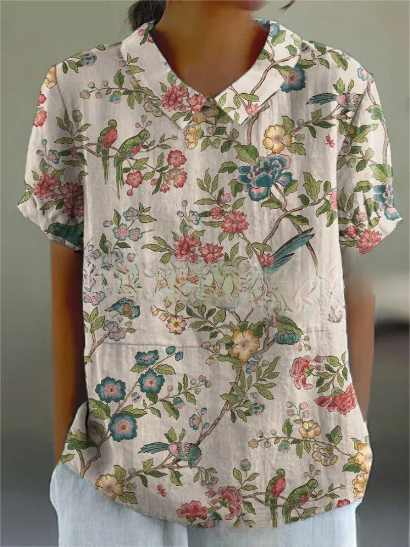 Graue Damen Bluse mit floralem Stickmuster und kurzen Ärmeln aus leichtem Stoff.