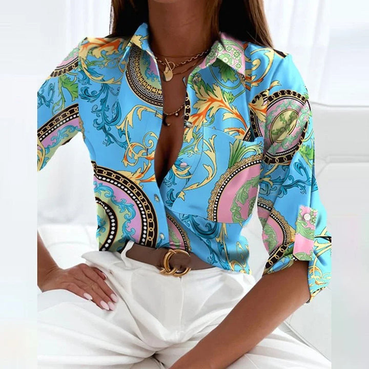 Blau bedruckte Damenbluse mit Umlegekragen und grafischem Muster aus Baumwolle und Polyester.