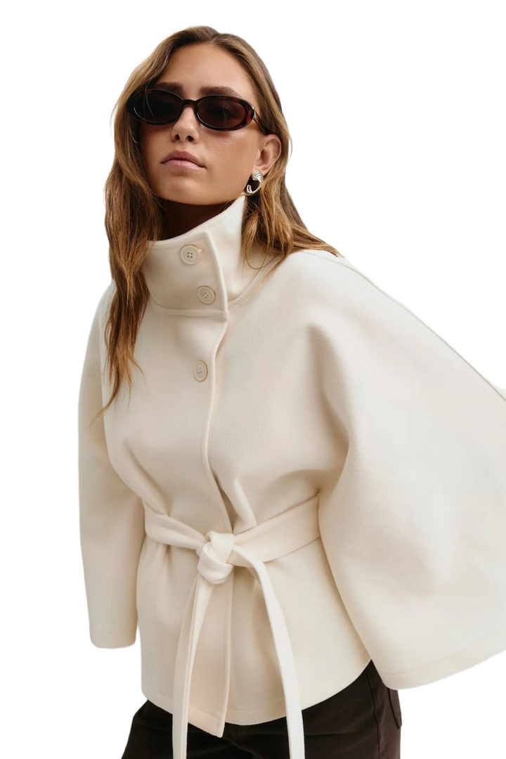 Beige Damen Cape-Mantel mit Stehkragen, Gürtelbindung und klassischem Design aus warmem, weichem Material.