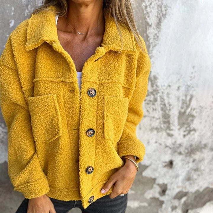 Gelbe Damen Fleecejacke mit Knopfverschluss, Brusttaschen und weichem Material für zusätzlichen Komfort und Wärme.