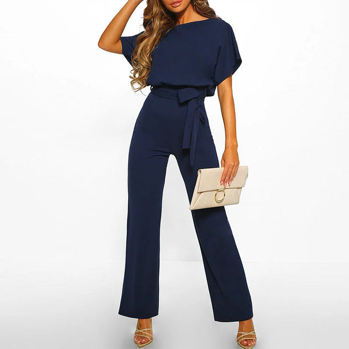 Dunkelblauer Damen Jumpsuit mit kurzem Ärmel und Gürtel, aus bequemem Stoff und schickem Design.