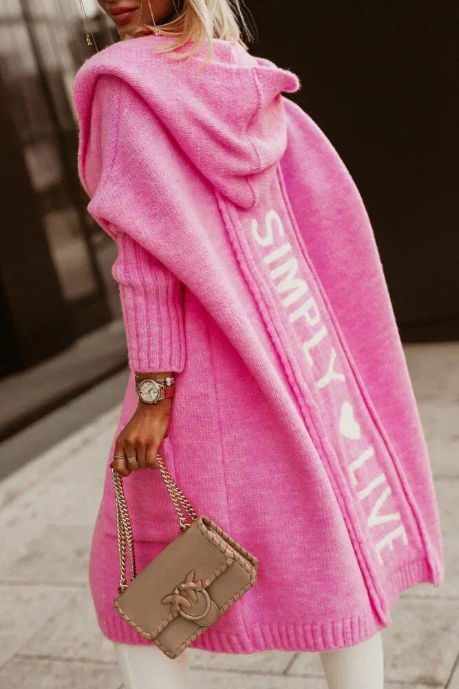 Rosa Damen Kapuzen-Strickjacke mit Schriftzug, praktischen Taschen und weichem Material für gemütlichen Tragekomfort.