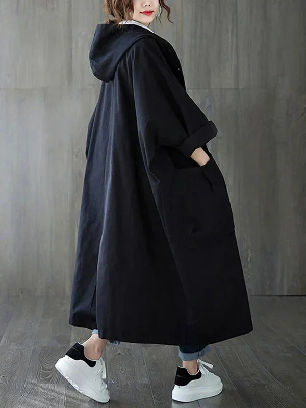 Schwarzer Damen Kapuzen-Trenchcoat aus Baumwolle mit großen Taschen und modernem, zeitlosen Design für Alltag und Freizeit.
