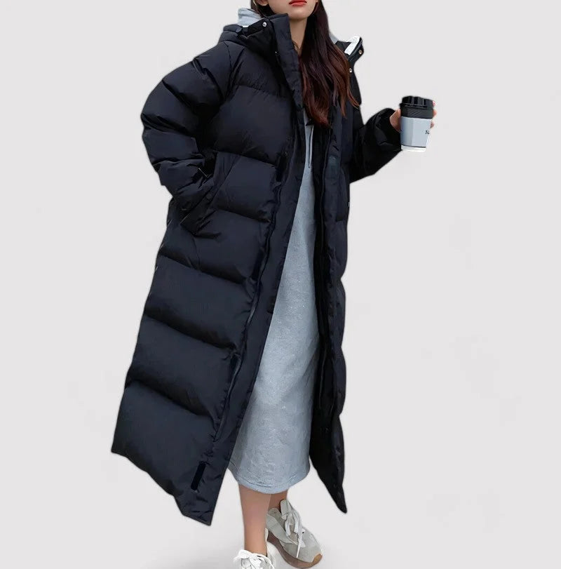 Damen wattierter Mantel mit Kapuze, lang geschnitten, aus warmem Material, ideal für kalte Tage im urbanen Stil.