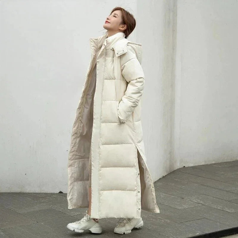 Beige Damen Lang Steppjacke mit Kapuze, gefüttert, seitlichen Taschen und leichtem, warmem Material für kühle Tage.