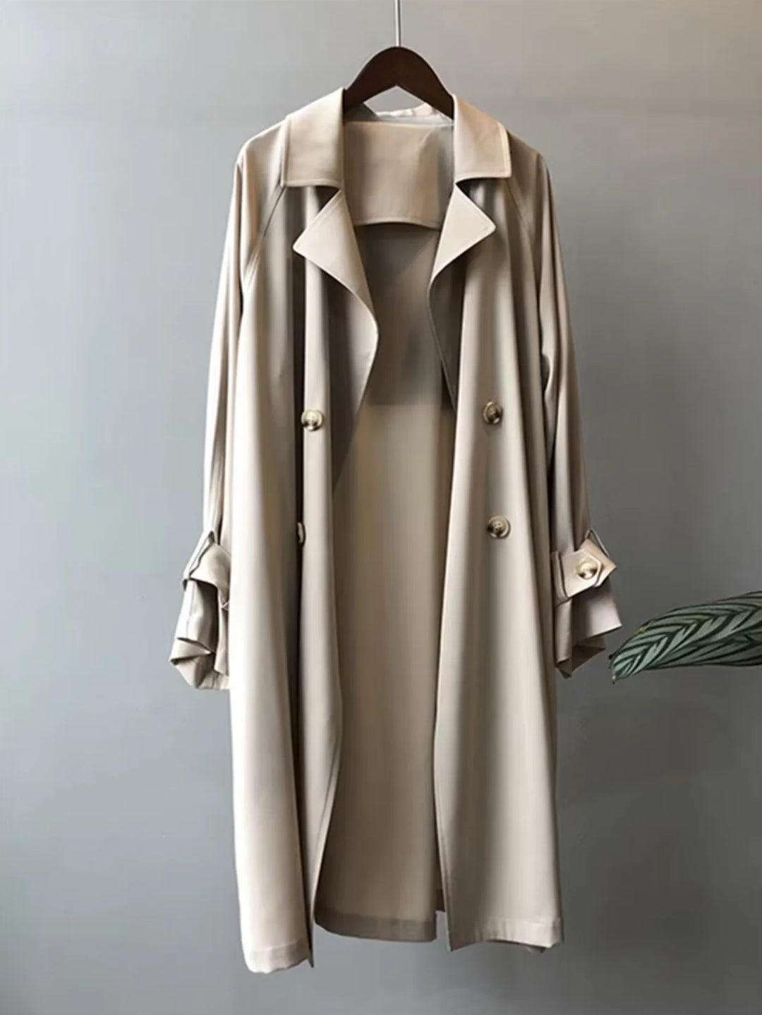 Beiger Damen-Trenchcoat aus robustem Material mit Gürtel und Knopfleiste, ideal für modische Anlässe und Übergangszeiten.