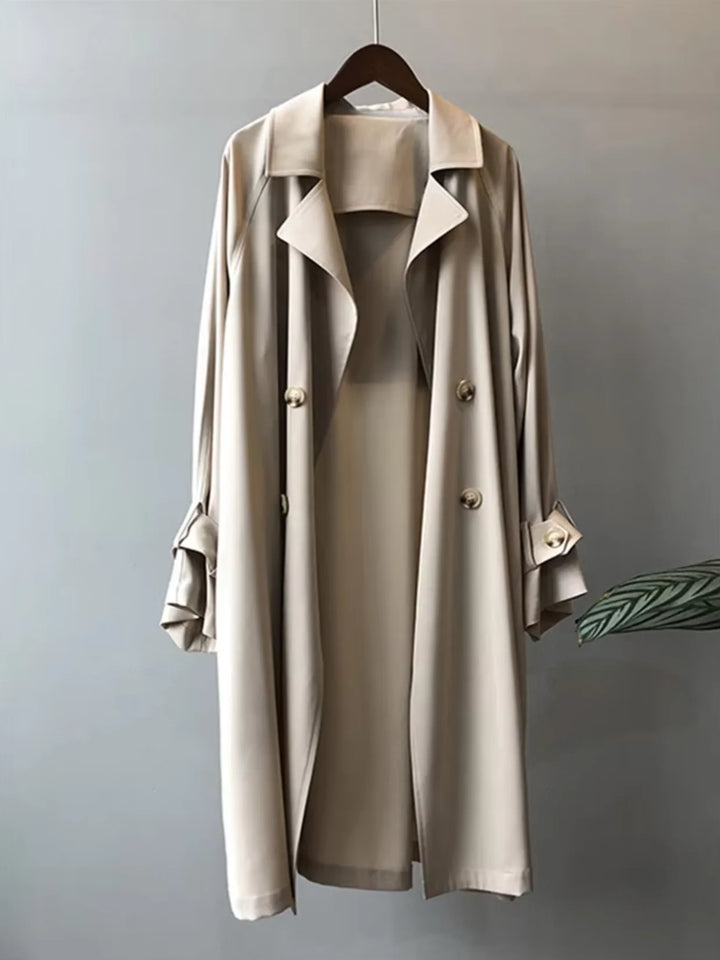 Beiger Damen-Trenchcoat aus robustem Material mit Gürtel und Knopfleiste, ideal für modische Anlässe und Übergangszeiten.