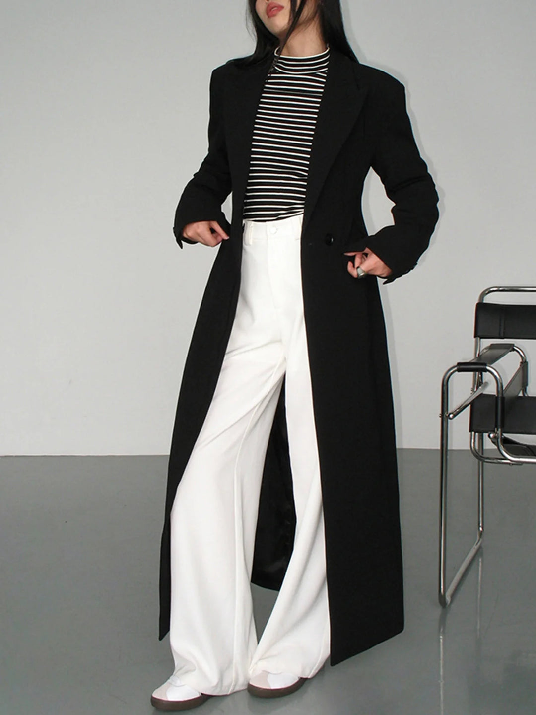 Damen Trenchcoat aus hochwertigem Stoff, lang geschnitten, schwarzes modernes Design mit tailliertem Schnitt.