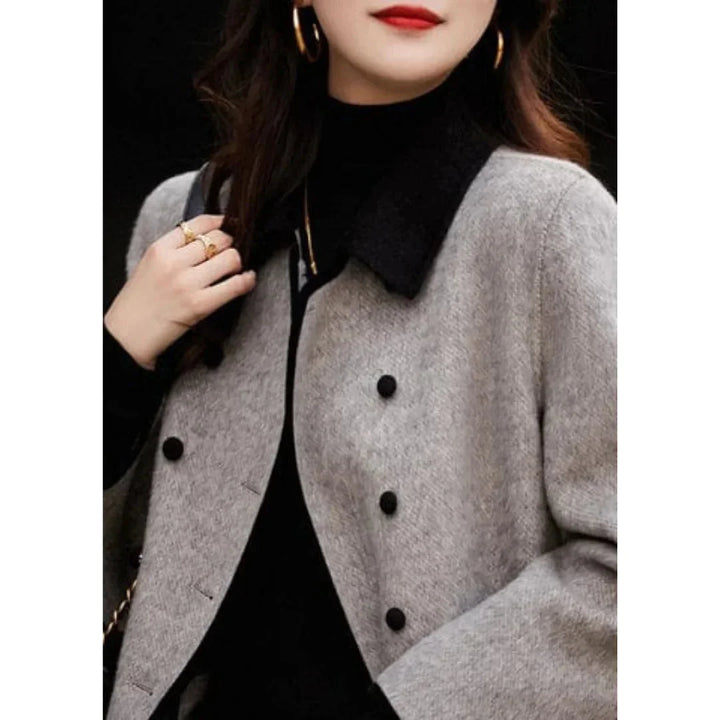 Damen Mantel mit Doppelreihe, schwarzem Kragen, aus weich strukturiertem Material, ideal für kühlere Tage.