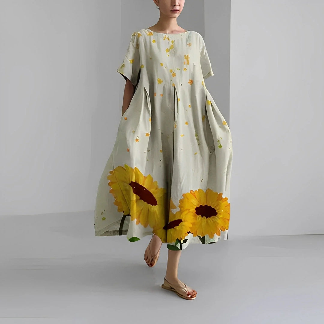 Hellgraues Damen Maxi-Kleid mit Sonnenblumen-Print, aus leichtem Stoff, luftig und bequem, perfekt für den Sommer.