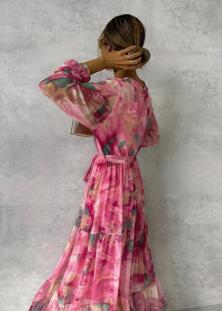 Rosa Maxi-Wickelkleid für Damen mit floralem Muster. Leichter Stoff, lang geschnitten, perfekt für den Sommer.