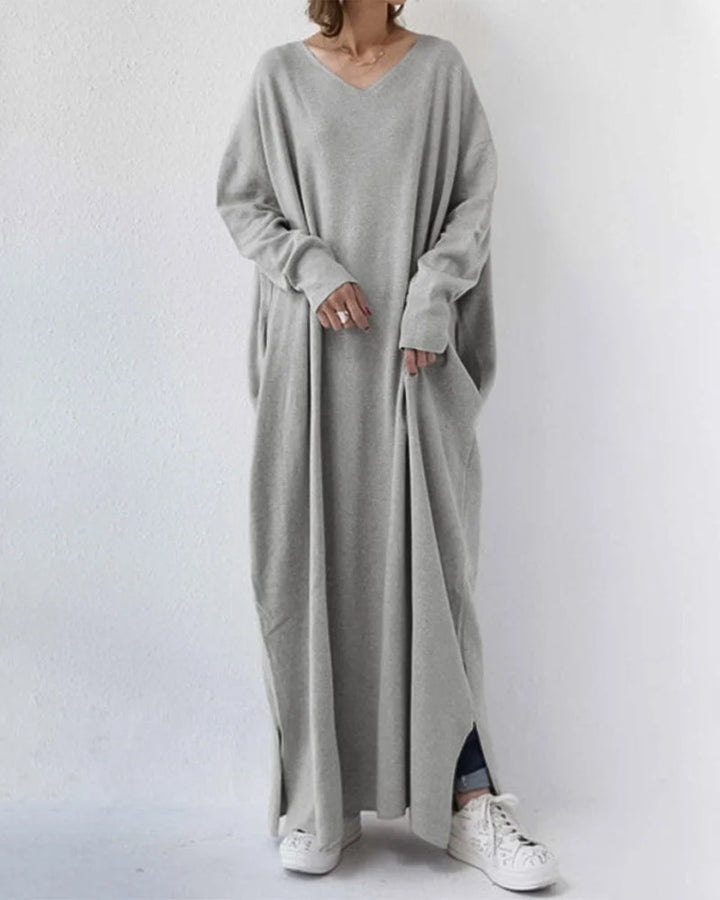 Graues Damen Maxikleid mit V-Ausschnitt, langen Ärmeln und fließendem Stoff für einen eleganten Look.