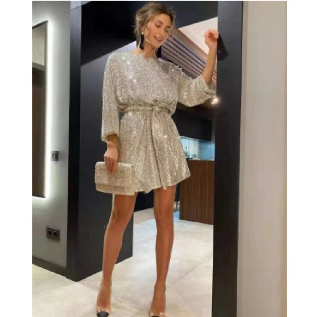 Goldenes Minikleid für Damen mit funkelndem Glitzer-Effekt und trendigen Ballonärmeln. Feiner Stoff und figurbetontes Design.