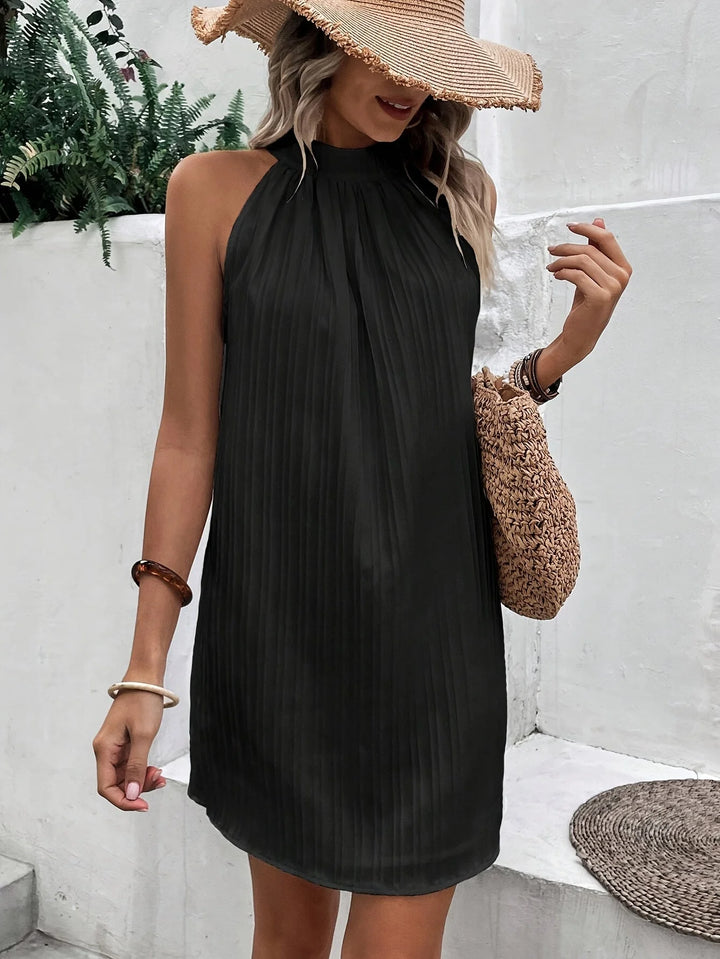 Schwarzes Damen Minikleid mit Neckholder und Plisseefalten in Anthrazit. Aus leichtem Stoff für einen eleganten Look.