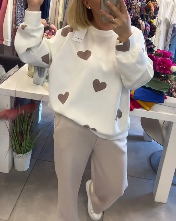 Damen Pullover aus Baumwollmix mit einem verspielten Herzmuster in sanften Farben. Bequem und leicht für den Alltag.