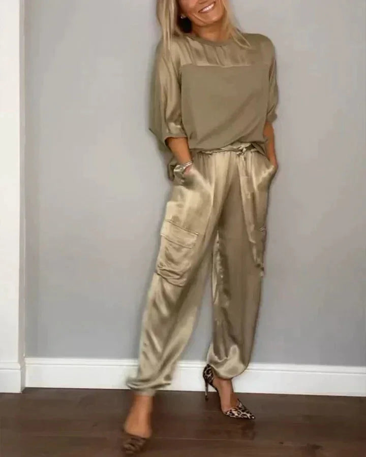 Goldfarbener Damen Satin Jumpsuit mit praktischen Taschen und einem eleganten Bindegürtel für einen stilvollen Look.