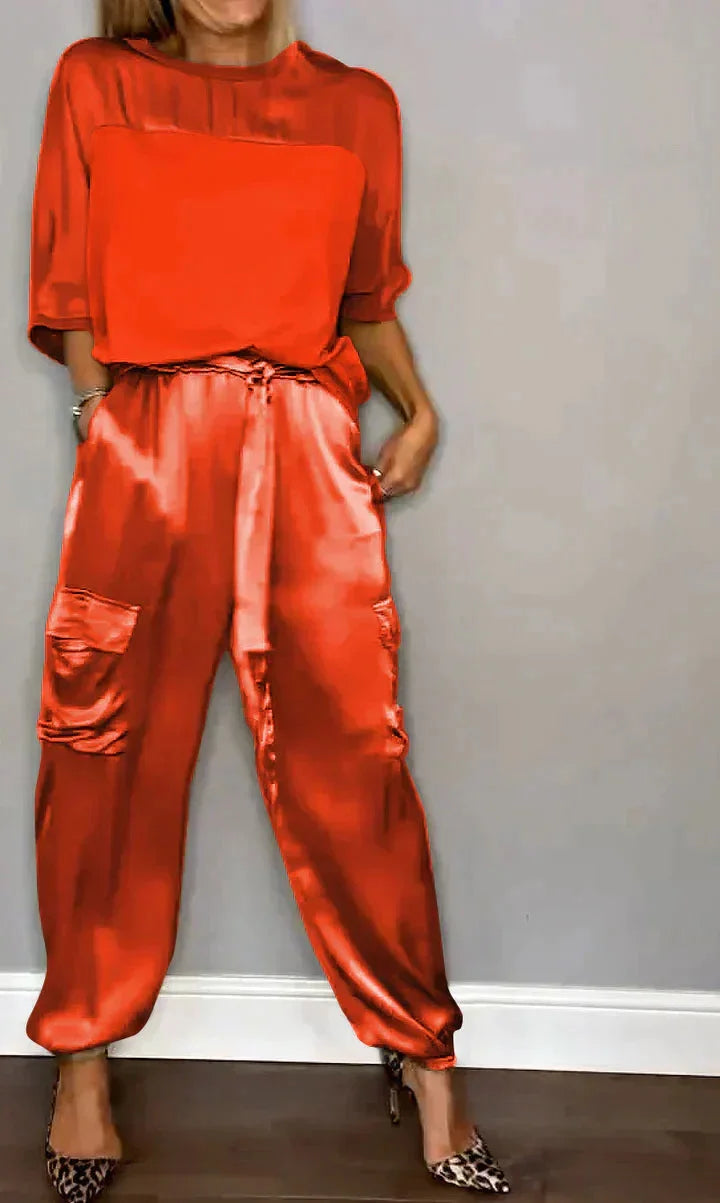 Roter Damen Satin Jumpsuit mit Taschen, Bindegürtel und schimmerndem Stoff für einen eleganten Look.