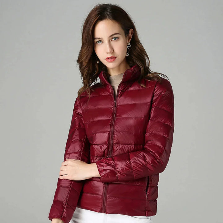 Damen Steppjacke aus warmem Material, mit Kapuze und seitlichen Taschen, ideal für kalte Tage.