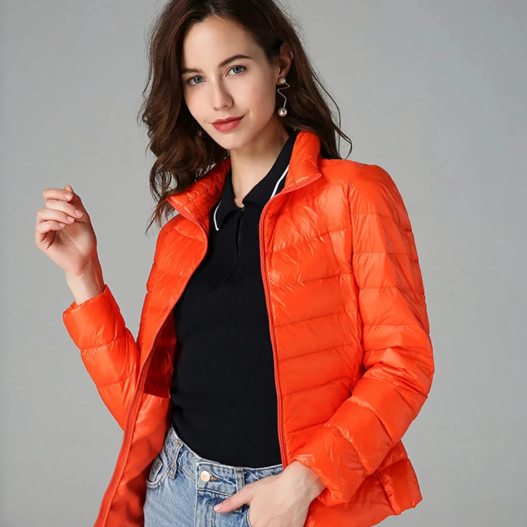 Orange Damen Steppjacke mit warmem Futter, praktische Taschen und durchziehbare Kapuze für kalte Tage.