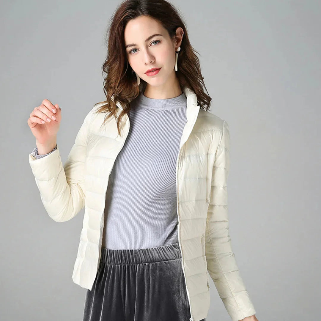 Damen Steppjacke in Weiß, gefüttert, wasserabweisend, mit Kapuze und seitlichen Taschen für zusätzliche Wärme.