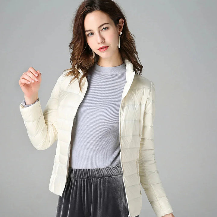 Damen Steppjacke in Weiß, gefüttert, wasserabweisend, mit Kapuze und seitlichen Taschen für zusätzliche Wärme.