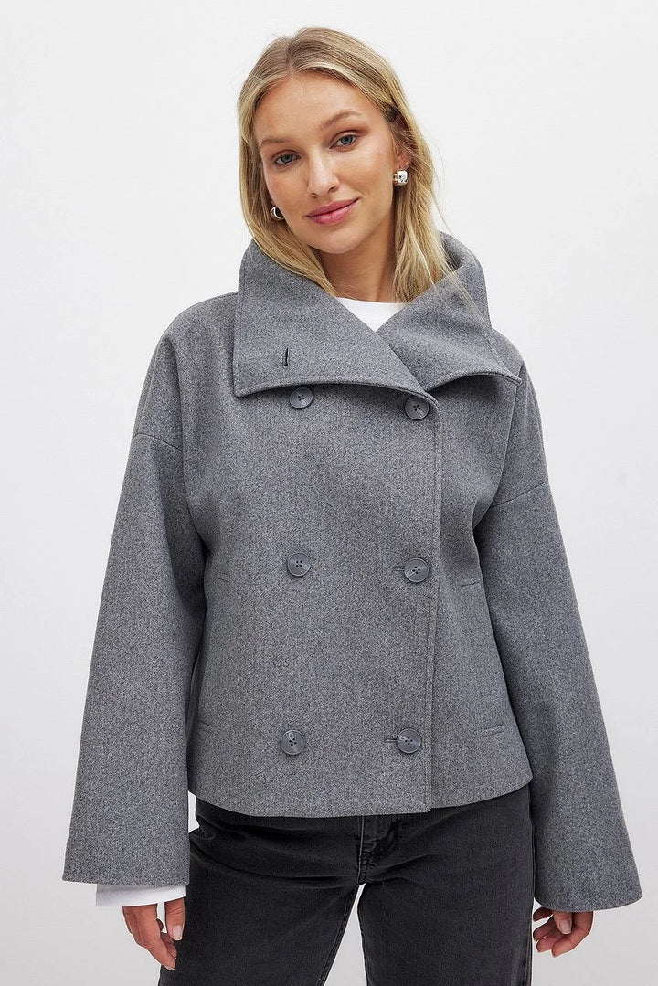 Dunkelgraue Damen Steppjacke, kurz mit doppelter Knopfleiste, Kragen und gestepptem Design für zusätzlichen Komfort.