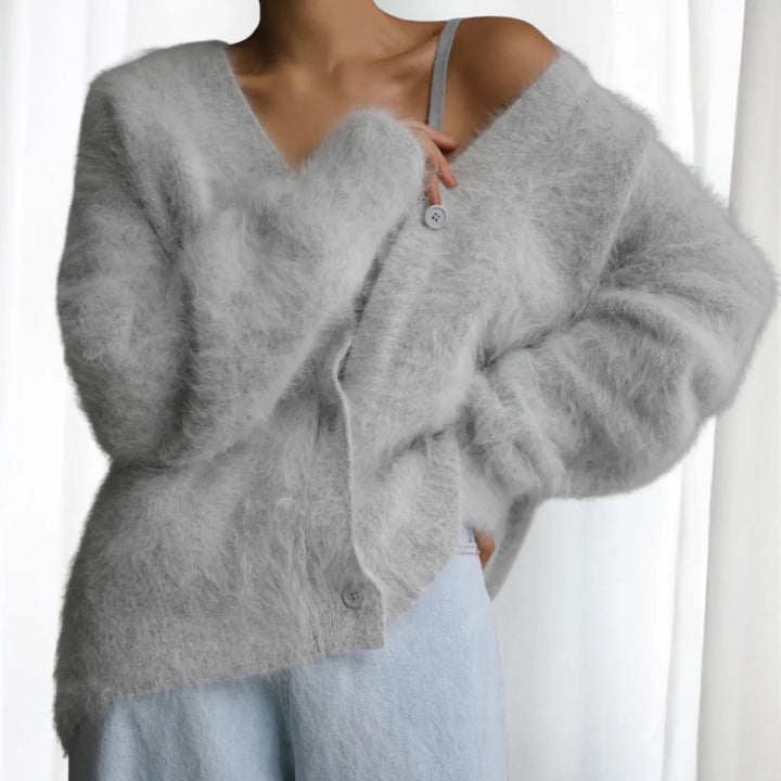 Hellgraue Damen Strickjacke mit Knopfleiste, überschnittenen Schultern und weichem, atmungsaktivem Strickmaterial.