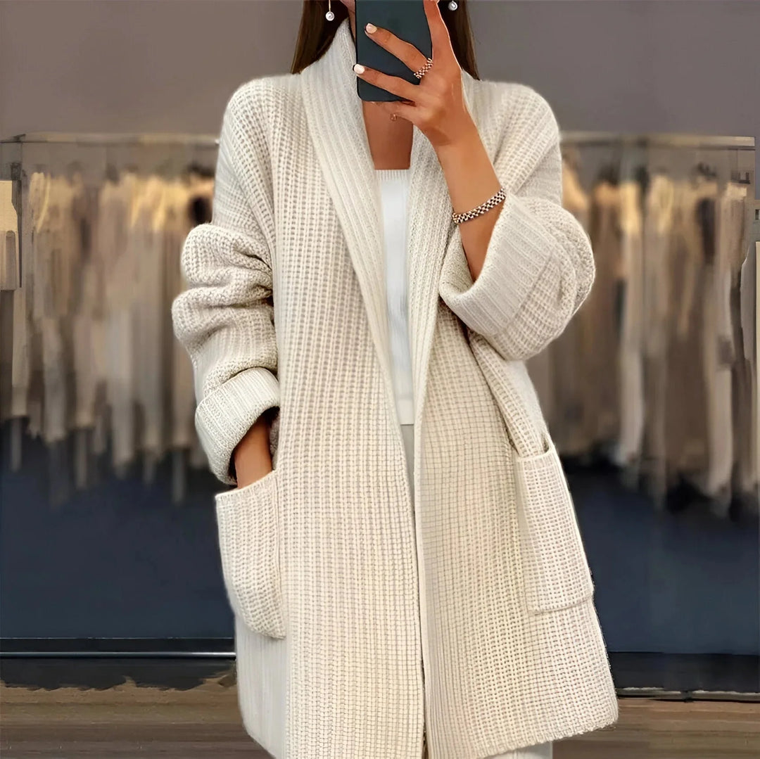 Zartbeige Damen Strickmantel mit Taschen, Schalkragen und weichem Material für Komfort und vielseitige Tragemöglichkeiten.