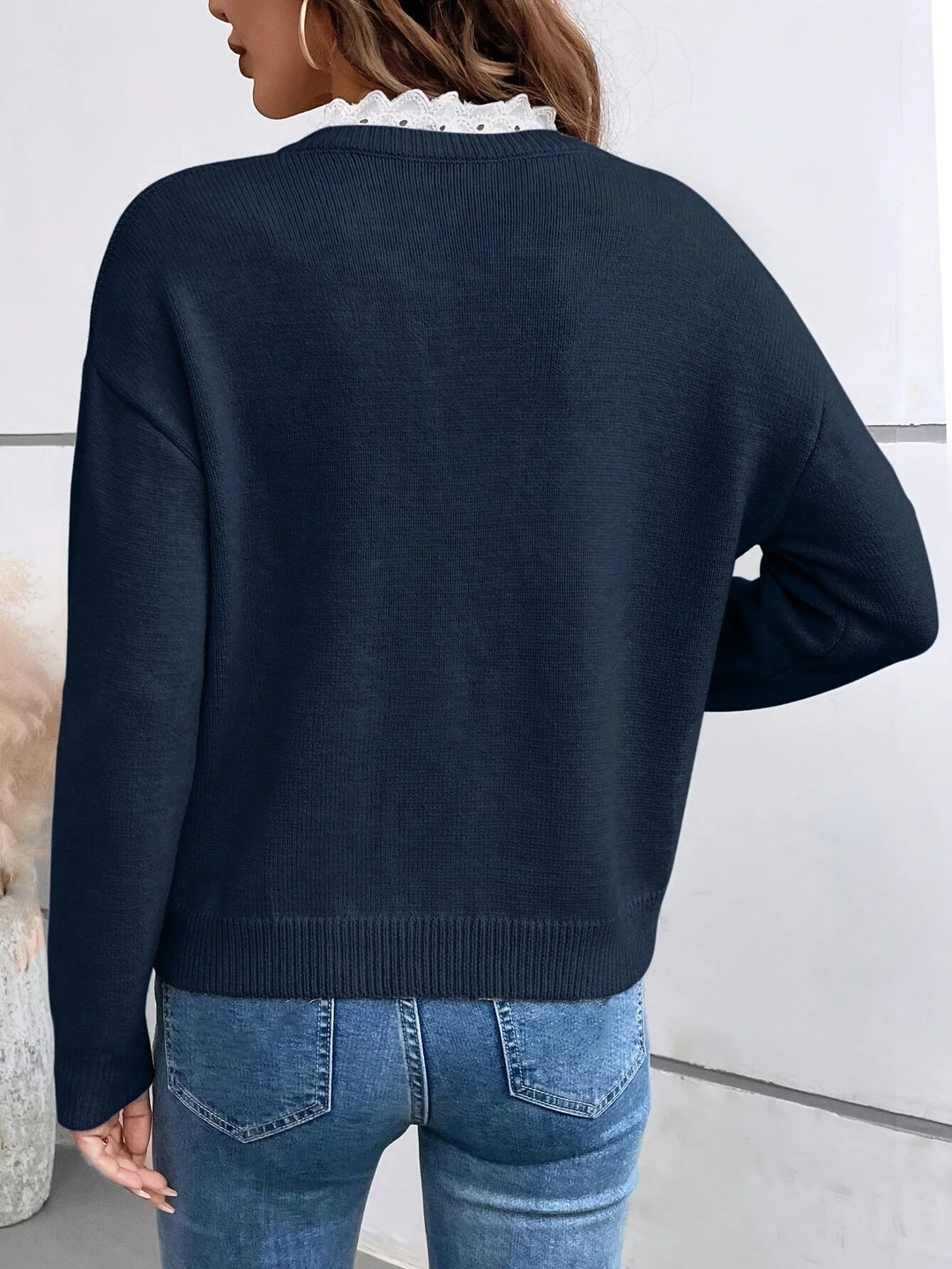 Damen Strickpullover aus weicher Wolle mit V-Ausschnitt und elegantem Spitzeneinsatz an den Schultern.