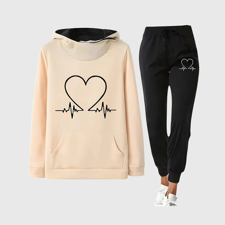 Damen Trainingsset in Gelb mit Herzmotiv, bestehend aus Kapuzenpullover und sportlicher Hose, aus atmungsaktivem Material.