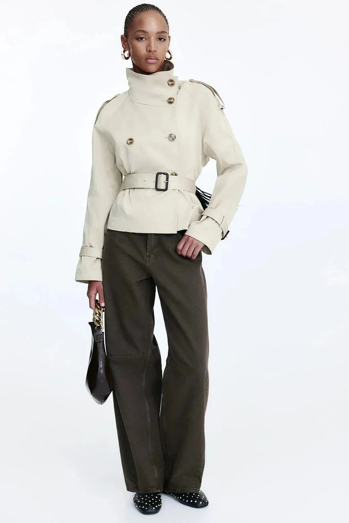 Damen Trenchcoat aus robuster Baumwolle, mit hohem Kragen, tailliertem Gürtel und klassischem Schnitt in Beige.