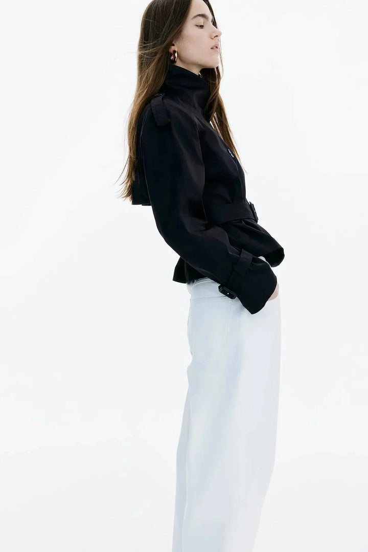 Damen Trenchcoat aus wetterfestem Material mit hohem Kragen und Taillengürtel für eine figurbetonte Passform.