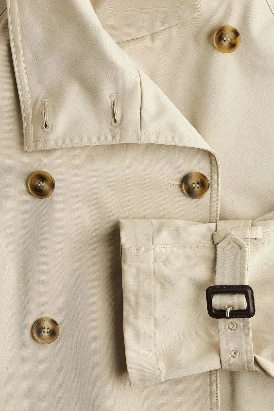 Damen Trenchcoat aus leichtem Baumwollmix mit hohem Kragen und tailliertem Gürtel in modernem Schnitt.
