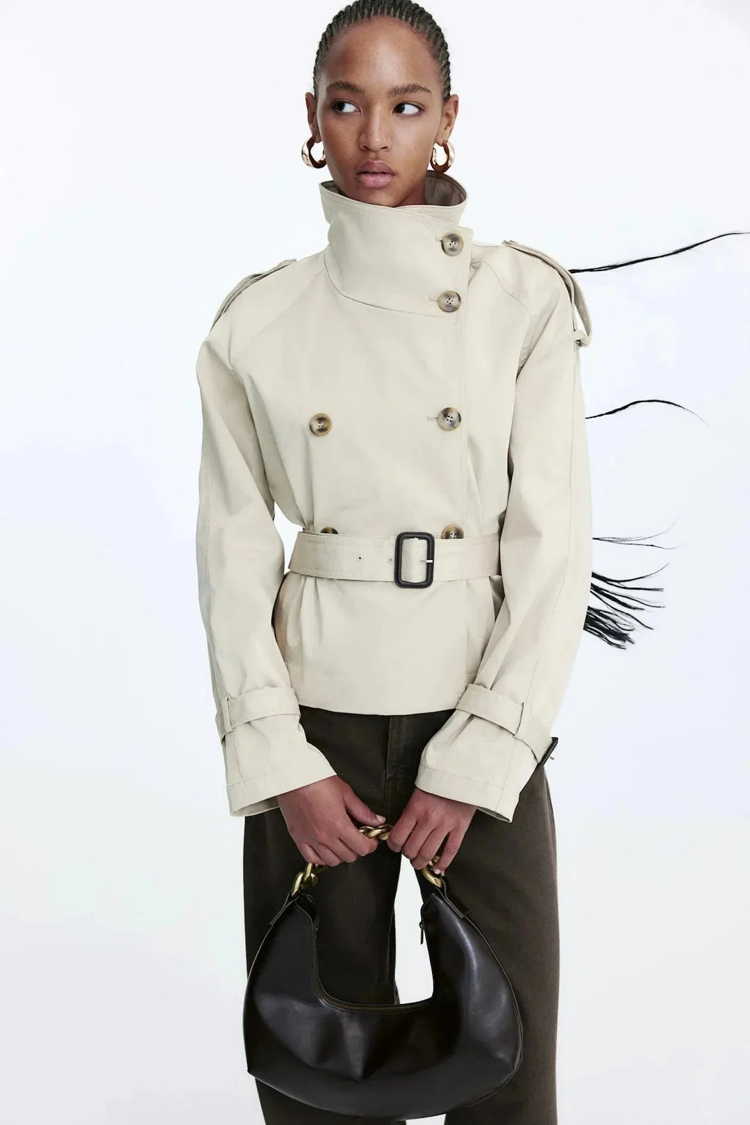 Beiger Damen Trenchcoat aus leichtem Material, mit hohem Kragen und taillierbarem Gürtel für eine individuelle Passform.