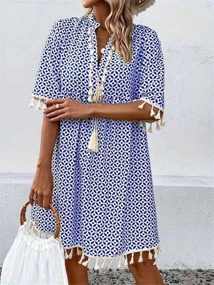 Weiß-blaues Tunika-Kleid für Damen mit Quasten, luftiger Stoff, perfekt für den Sommer, lässiger Look, Muster in Blau-Weiß.