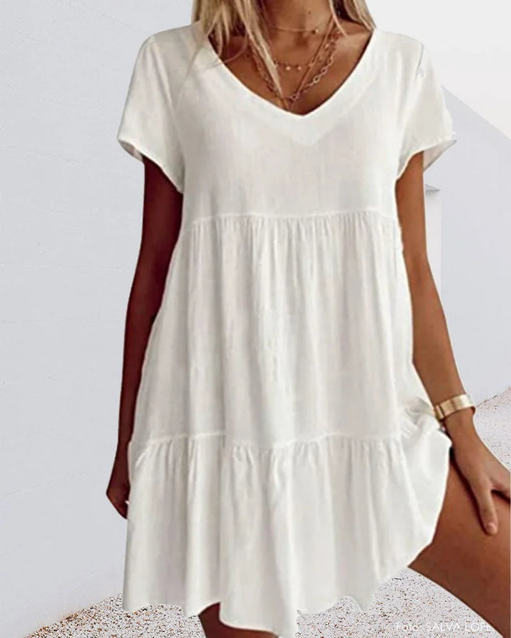 Weißes Leinenkleid für Damen mit V-Ausschnitt, Rüschen und Kurzarm. Leicht und luftig, perfekt für den Sommer.