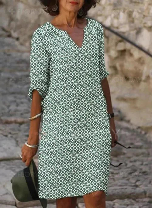 Grünes Damen V-Ausschnitt Midikleid mit geometrischem Muster aus leichtem Stoff. Feminin geschnitten und ideal für den…