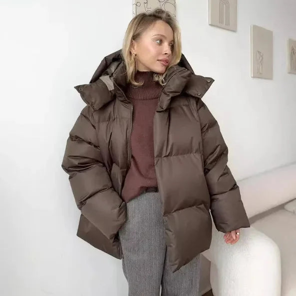 Braune Damen Winter-Pufferjacke mit Kapuze, Stehkragen und praktischen Taschen, ideal für kalte Wetterbedingungen.
