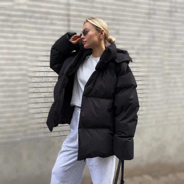 Schwarze Damen Winter-Pufferjacke mit Kapuze, Stehkragen und durchgehendem Reißverschluss, isolierend und wasserabweisend.
