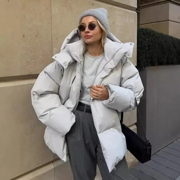 Weiße Damen Winter-Pufferjacke mit Kapuze, Stehkragen und warmem Futter, ideal für kalte Tage.