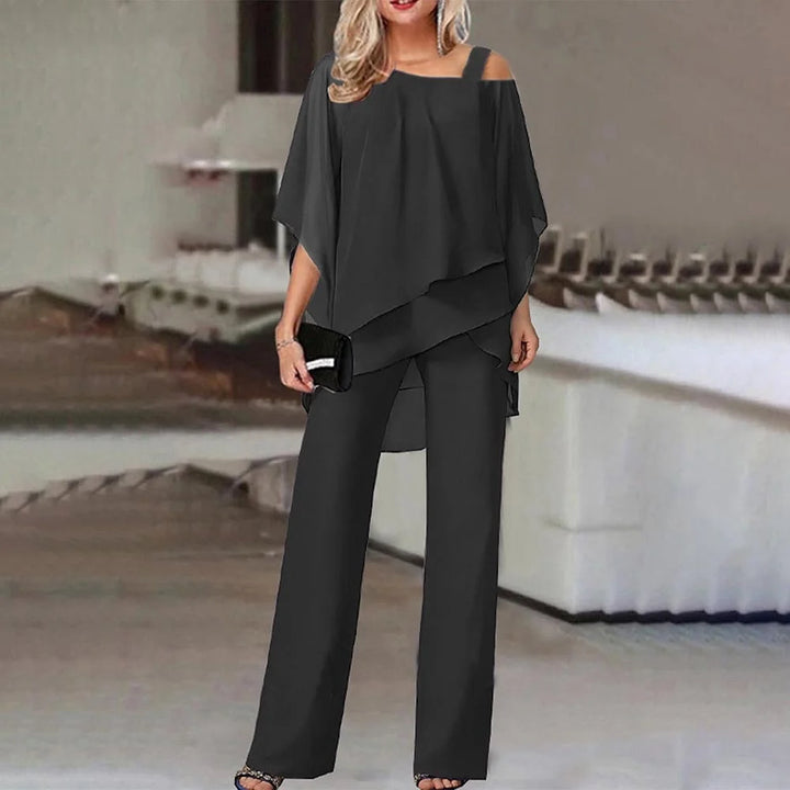 Schwarzer Damen Zweiteiler mit Cold-Shoulder-Bluse und weiten Hosen aus leichtem Stoff, perfekt für einen stilvollen und…