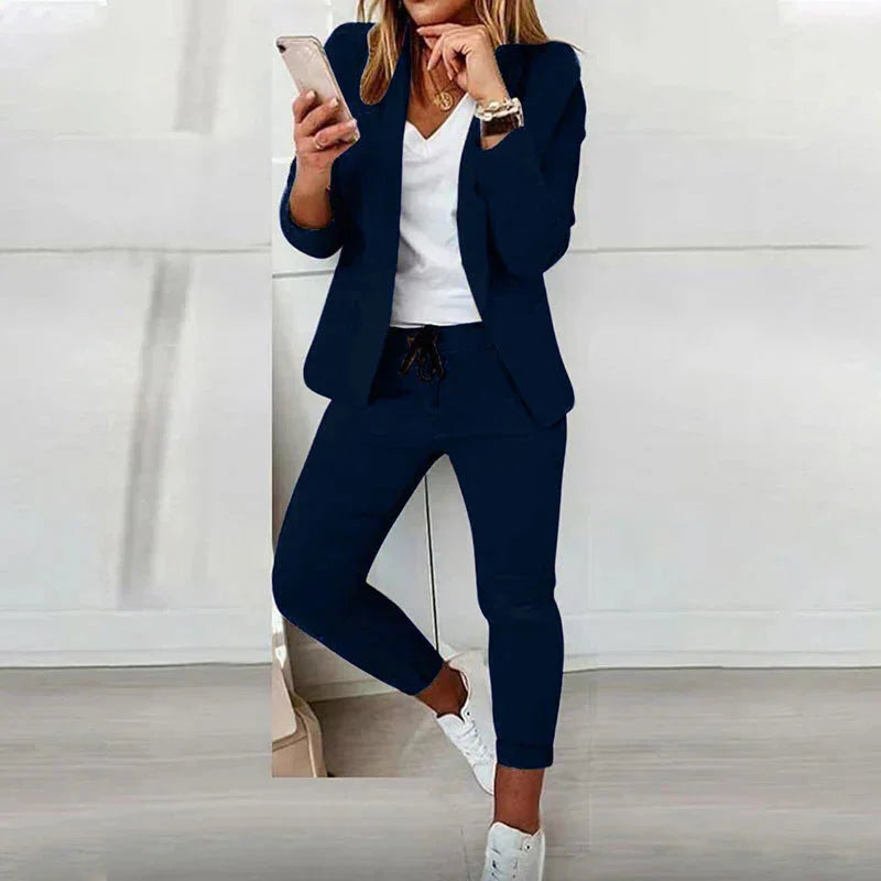 Damenanzug in Marineblau mit Joggerhose und Blazer, aus weichem Baumwollmix, lässiger Schnitt für den Alltag.